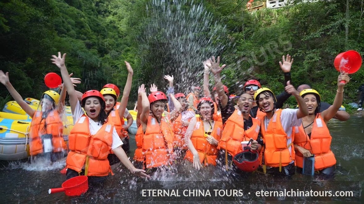 Travelers in life vests splashing water on a river rafting trip
